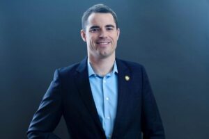 Roger Ver poses in a suit following his $48 million DOJ tax fraud settlement.