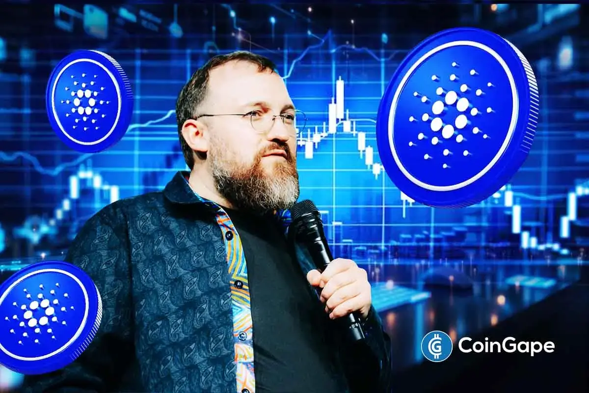 Charles Hoskinson speaks into a microphone beside the Cardano logo during network slowdown discussions.