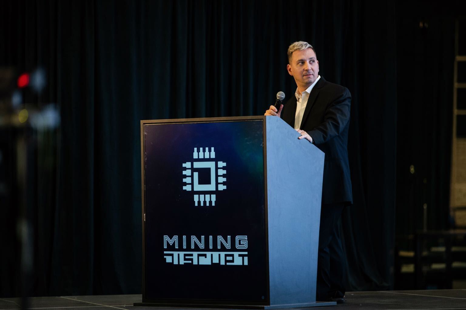 Michael Jerlis speaking on stage at Mining Disrupt 2025