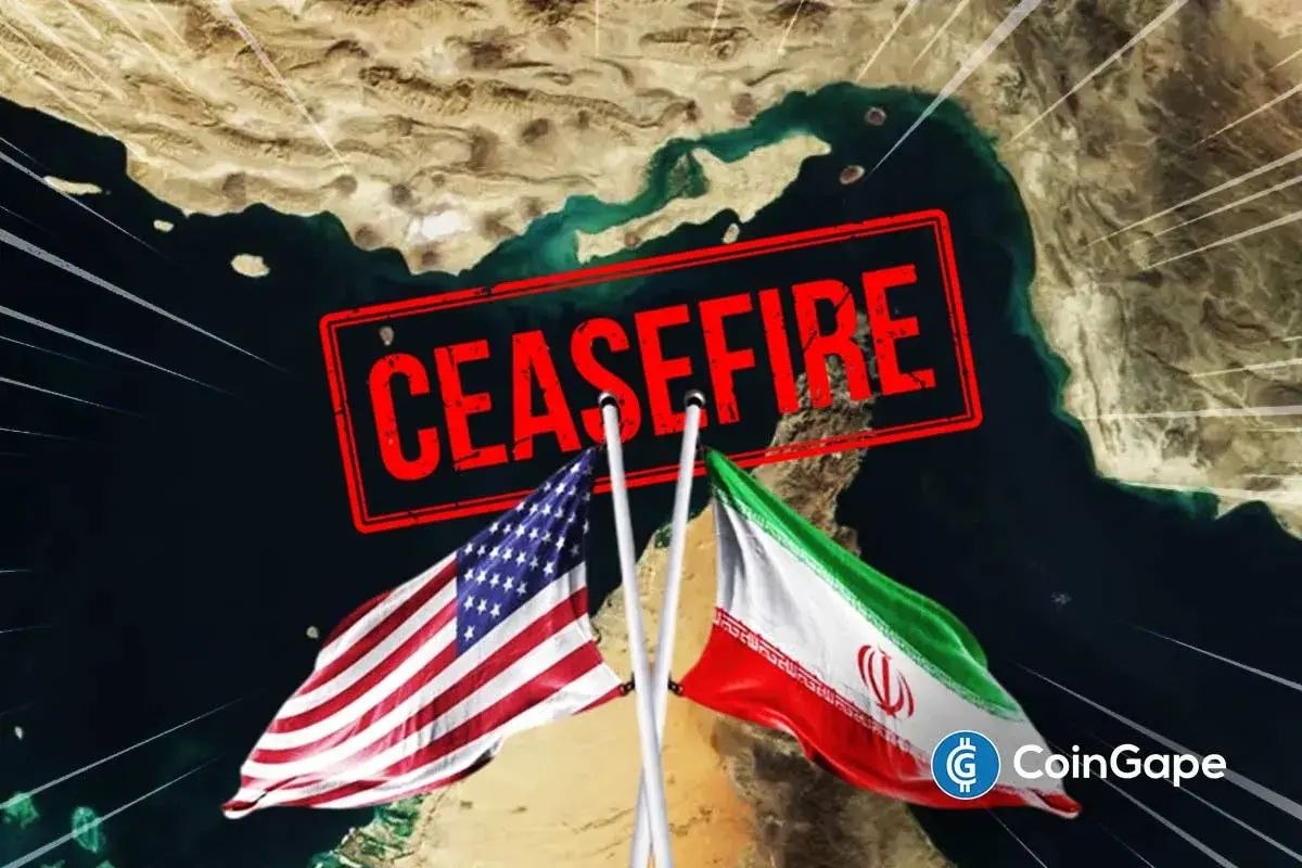 Cargo ships and oil tankers stalled in the Strait of Hormuz under heavy military monitoring following a U.S.-Iran ceasefire, with limited vessel movement visible.